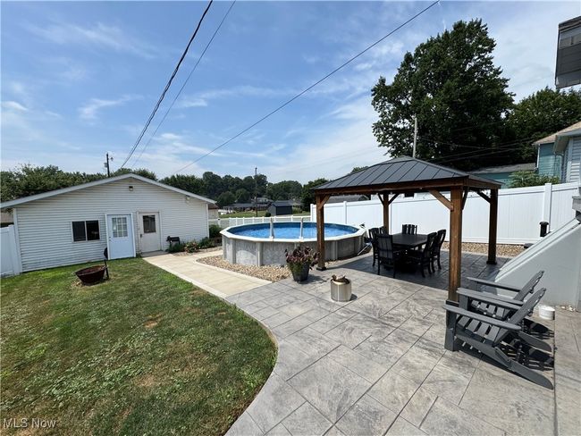 View of swimming pool with a fenced backyard, a gazebo, a patio area, outdoor dining space, and an outdoor fire pit | Image 37