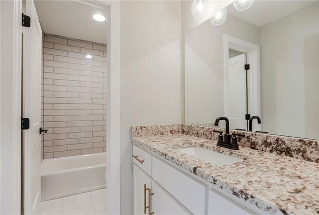 Bathroom with vanity, recessed lighting, shower / washtub combination, and marble look tiles | Image 20