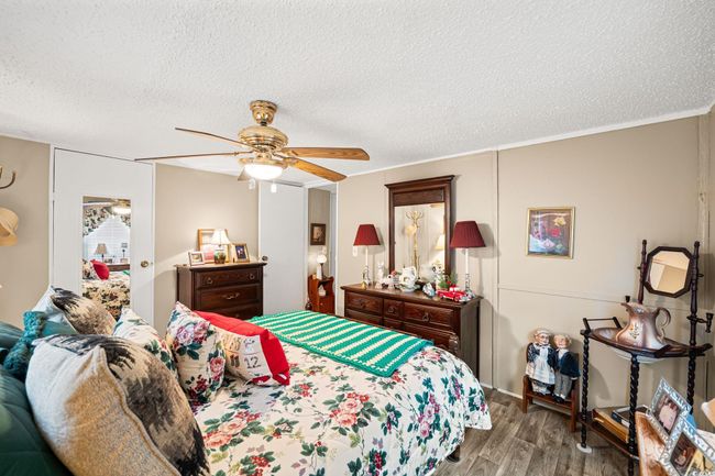 Bedroom with wood finished floors, a textured ceiling, and ceiling fan | Image 11