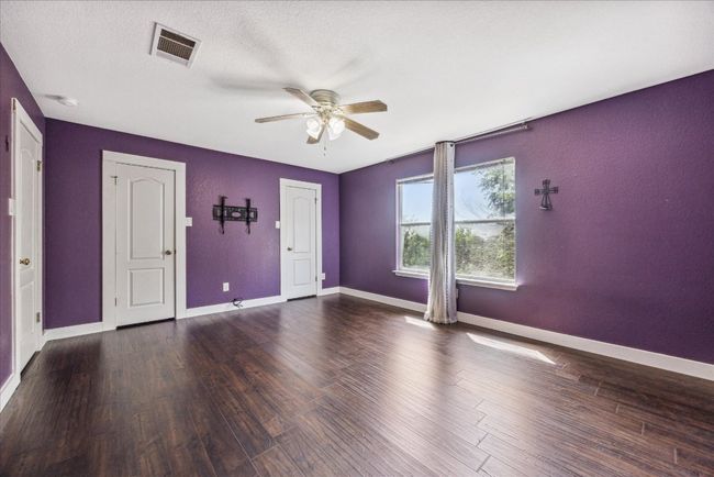 Unfurnished room featuring wood finished floors, visible vents, a ceiling fan, and baseboards | Image 24
