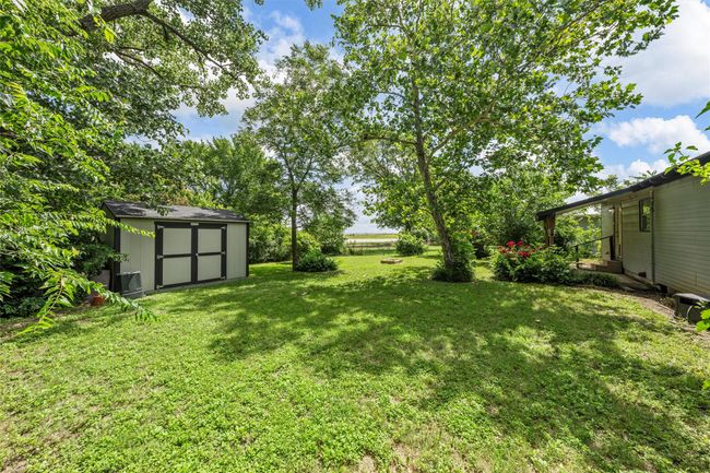 View of green lawn with a storage shed | Image 23