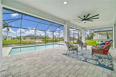 View of pool featuring a patio area, a lanai, an outdoor living space, and ceiling fan | Image 3