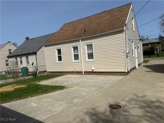 Rear view of property featuring fence, a patio area, and roof with shingles | Image 6