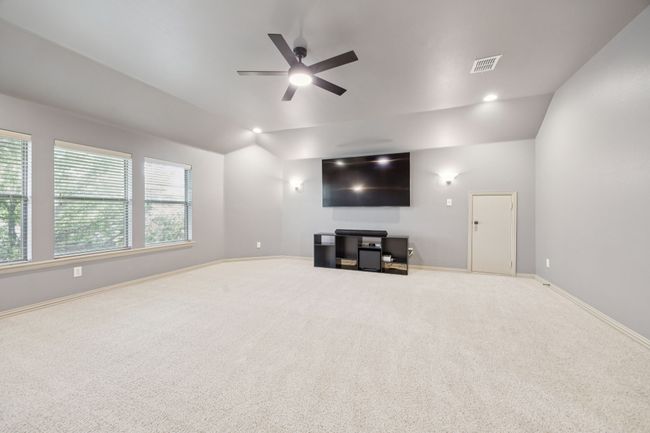 Unfurnished living room featuring vaulted ceiling, a ceiling fan, carpet floors, and baseboards | Image 28