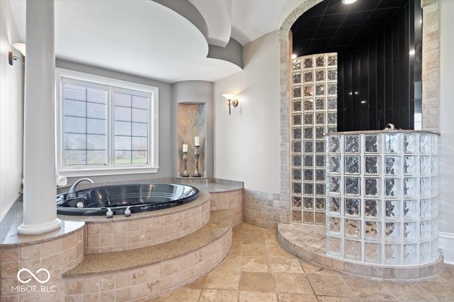 Expansive primary en-suite with circular jetted tub and walk-in shower. | Image 32