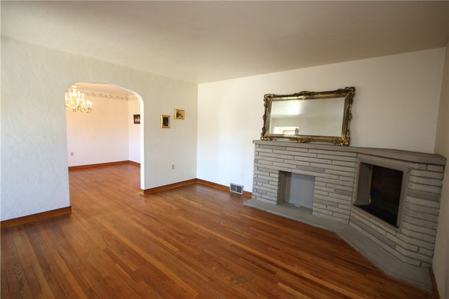 Large 14x13 Living Room w/ Decorative Stone Fireplace & Hardwood Floors which flow through-out into both Bedrooms also. Quality Built w/ Plaster Walls too! | Image 4