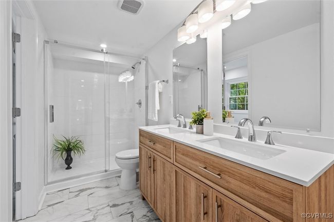 Gorgeous primary bath with adult height double vanity, LVT flooring, and walk in shower | Image 31