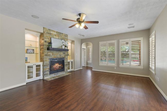 Family room overlooks the back pool area, has neutral paint, updated flooring, Plantation shutters and is open to the kitchen/breakfast area. | Image 14