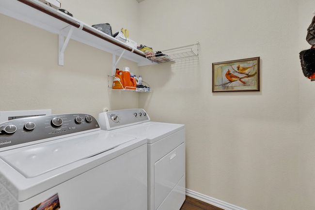 Laundry room with dark wood-style flooring, baseboards, separate washer and dryer, and laundry area | Image 22