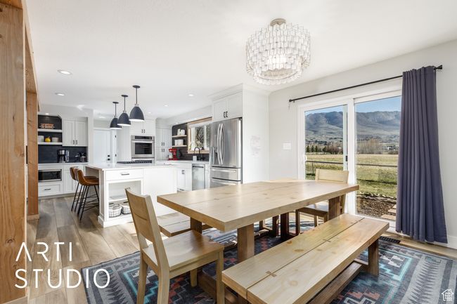 Dining space with an inviting chandelier, light wood-style floors, a mountain view, and recessed lighting | Image 15