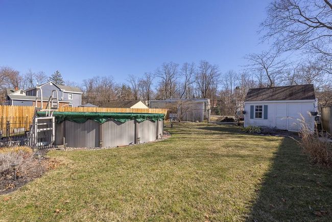 View of yard featuring a fenced in pool, an outdoor structure, and fence | Image 23