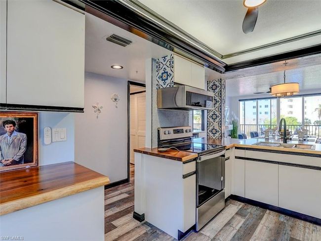 VIEW FROM KITCHEN TOWARDS UNIT ENTRANCE (LEFT). LOUVERED DOORS HIDE WASHER/DRYER. | Image 17