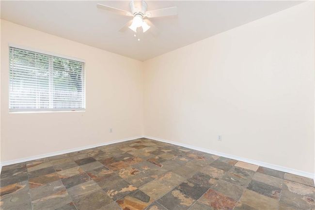 Unfurnished room with stone finish floors and ceiling fan | Image 6