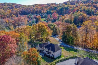 A stunning aerial view showcases this private property, nestled amidst lush trees for ultimate privacy, yet conveniently located just minutes from all local amenities. | Image 2