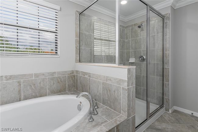 Bathroom featuring tile floors, ornamental molding, and separate shower and tub | Image 26