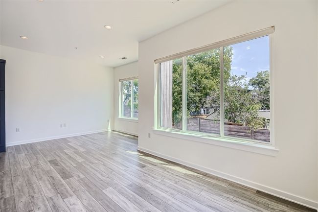 The open main floor layout is flooded with natural light from large windows, creating an inviting and airy ambiance. | Image 16