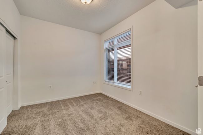 Unfurnished bedroom with carpet, a closet, and baseboards | Image 12
