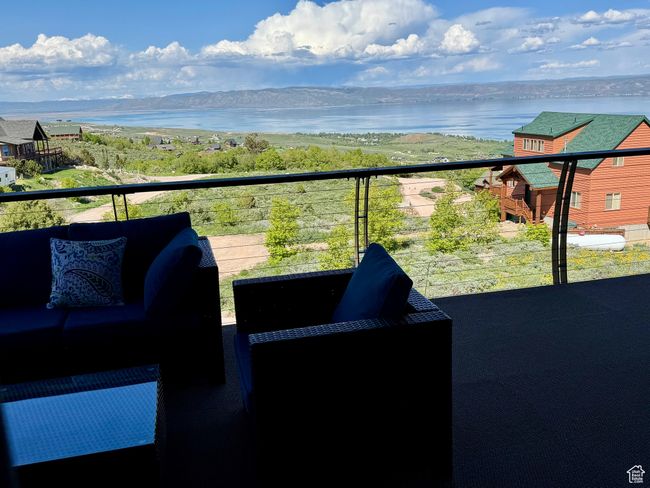 Covered deck featuring a lake view and new outdoor furniture | Image 28