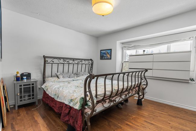 Bedroom with a textured ceiling, baseboards, and wood finished floors | Image 17
