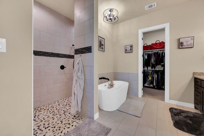 Bathroom featuring a soaking tub, walk in shower, tile patterned flooring, vanity, and tile walls | Image 20