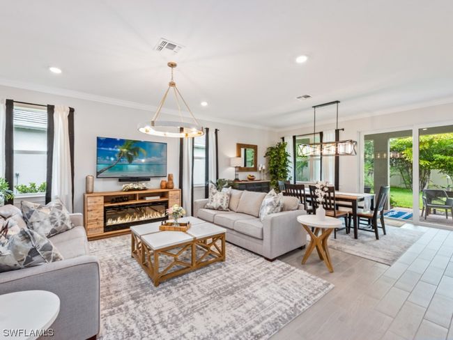 Experience the epitome of Florida living in this new home's open concept Great Room/ Dining Room/ Kitchen, where abundant windows and 8' tall sliding glass doors invite the outdoors in | Image 6