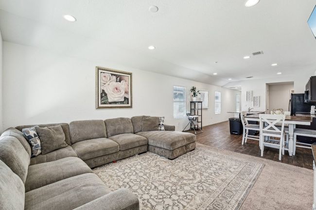 Living room featuring dark wood-style floors, visible vents, recessed lighting, and lofted ceiling | Image 4