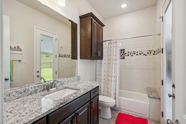 Full bathroom with shower / tub combo, toilet, vanity, and tile patterned floors | Image 30