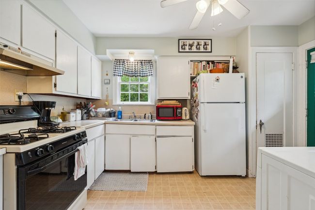 Kitchen with gas stove, storage, and washer/dryer area | Image 9