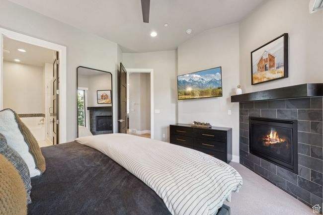Bedroom featuring a fireplace, carpet flooring, recessed lighting, connected bathroom, and lofted ceiling | Image 16