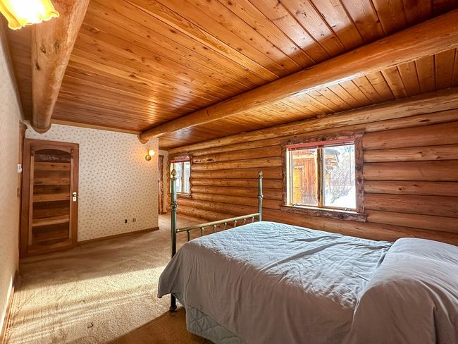 Bedroom featuring wood ceiling, beam ceiling, log walls, and carpet flooring | Image 39