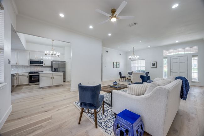 Living area with a chandelier, crown molding, a ceiling fan, light wood-type flooring, and recessed lighting | Image 8