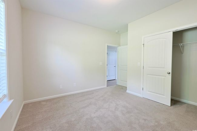 Unfurnished bedroom with carpet flooring and a closet | Image 18
