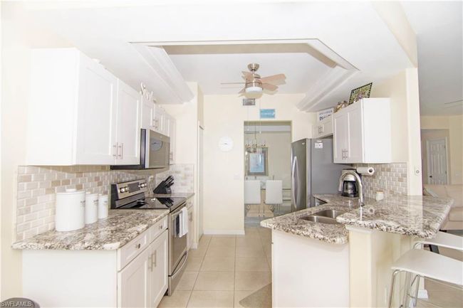Enjoy preparing meals in this fabulous remodeled kitchen with shaker cabinetry; dimensional tile backsplash; attractive granite and stainless appliances. | Image 10