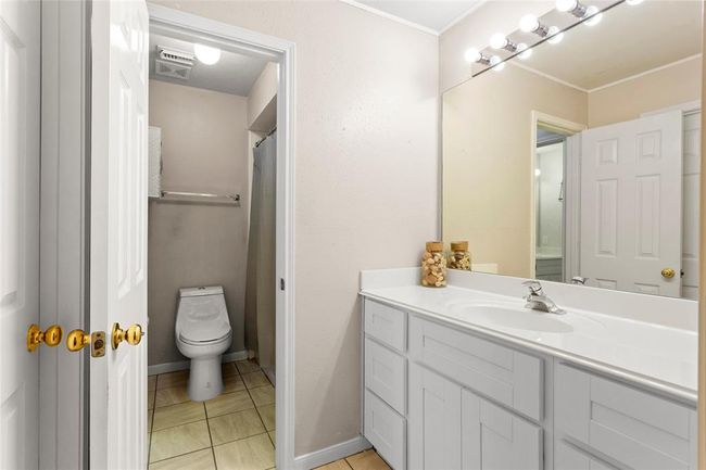 1st Vanity for Jack and Jill restroom, view to shared toilet and shower/ tub combo room. Walk in closet directly across from vanity. | Image 30