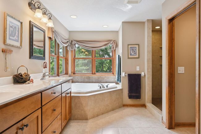 The main bath offers heated floors, dual vanity sinks, a large spa tub, and a separate walk-in shower. | Image 16