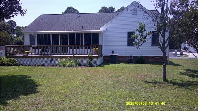 Rear view of house with a sunroom, a wooden deck, a lawn, roof with shingles, and crawl space | Image 4