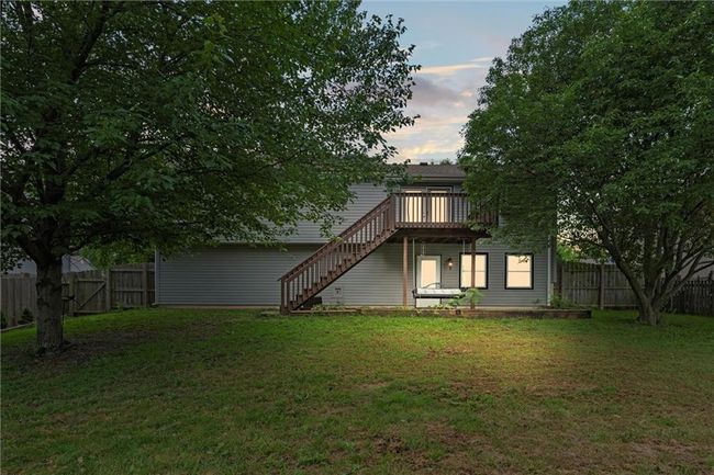 Back of house at dusk featuring stairway, a fenced backyard, and a deck | Image 39