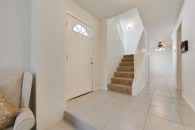 Foyer entrance featuring ceiling fan, light tile patterned flooring, and a textured ceiling | Image 11