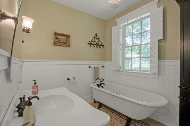Bathroom featuring a wainscoted wall, a freestanding tub, a sink, and a decorative wall | Image 31