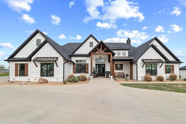 Modern farmhouse with board and batten siding, a chimney, a standing seam roof, and metal roof | Image 4