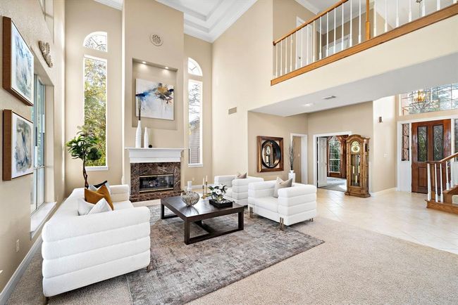 The architectural elegance of this home exudes timeless sophistication. With soaring ceilings and elongated arched windows, the structure itself bathes the interior in natural light, enhancing the expansive feel of the space." | Image 14