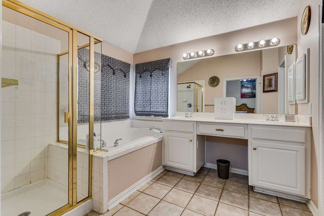 Bathroom with a separate shower, a garden tub, double vanity, tile patterned flooring, and vaulted ceiling | Image 26