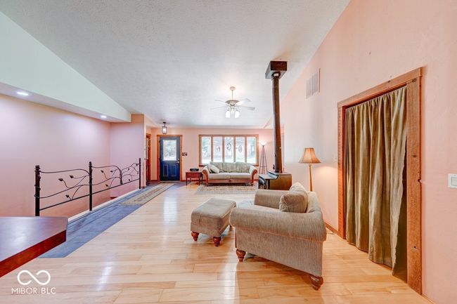 living area with lofted ceiling, light wood-style flooring, and a ceiling fan | Image 50
