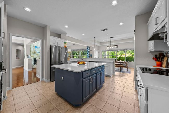 the inviting kitchen is a chef's delight, featuring a center island, beautiful quartz counters | Image 9