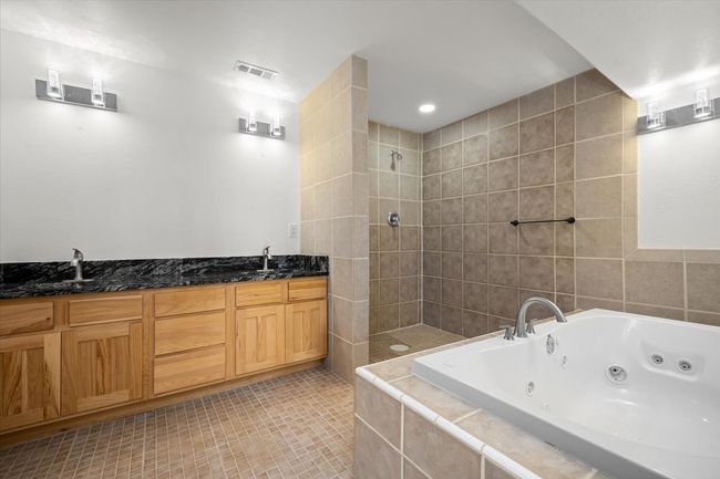 Bathroom with a tile shower, a whirlpool tub, tile patterned flooring, and double vanity | Image 8