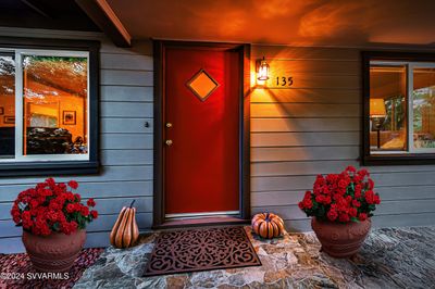 Welcoming Entry features Red front door, with Geraniums flanking the entrance. | Image 1