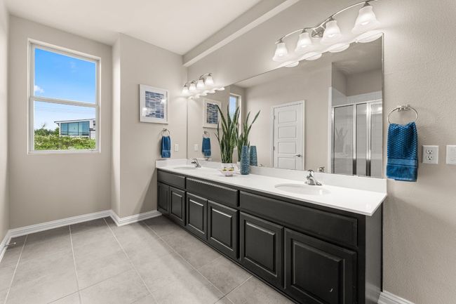 Full bathroom with double vanity, a shower stall, and tile patterned flooring | Image 14