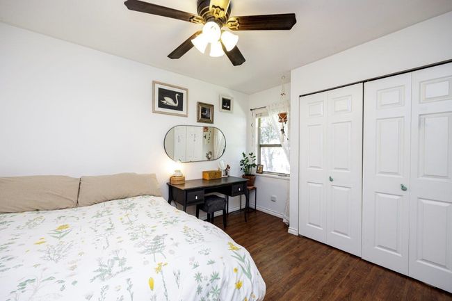Bedroom with a closet, baseboards, ceiling fan, and wood finished floors | Image 12