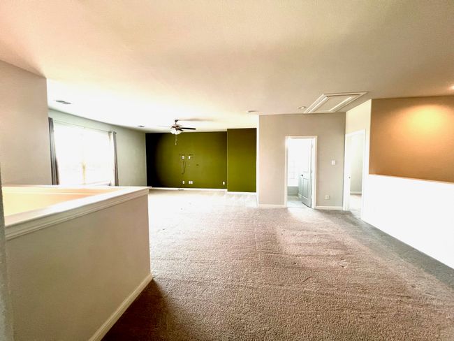 Unfurnished room featuring attic access, carpet, and ceiling fan | Image 21