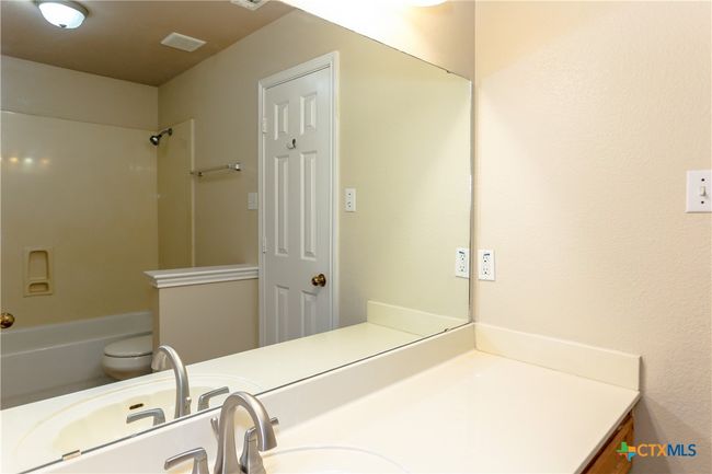 Hall bathroom showing the shower/tub combo, toilet and sink. New mirrors. | Image 21